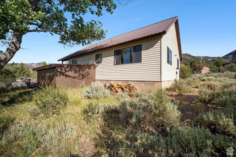View of property exterior featuring a metal roof and a mountain view