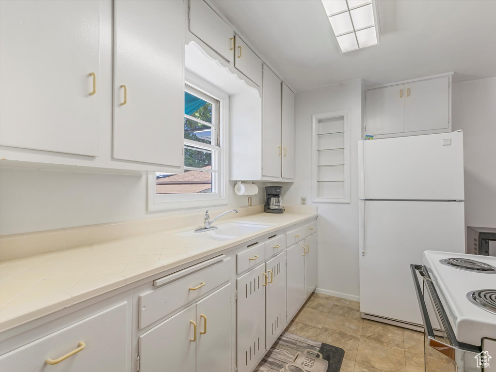 Kitchen featuring white appliances and white cabinetry