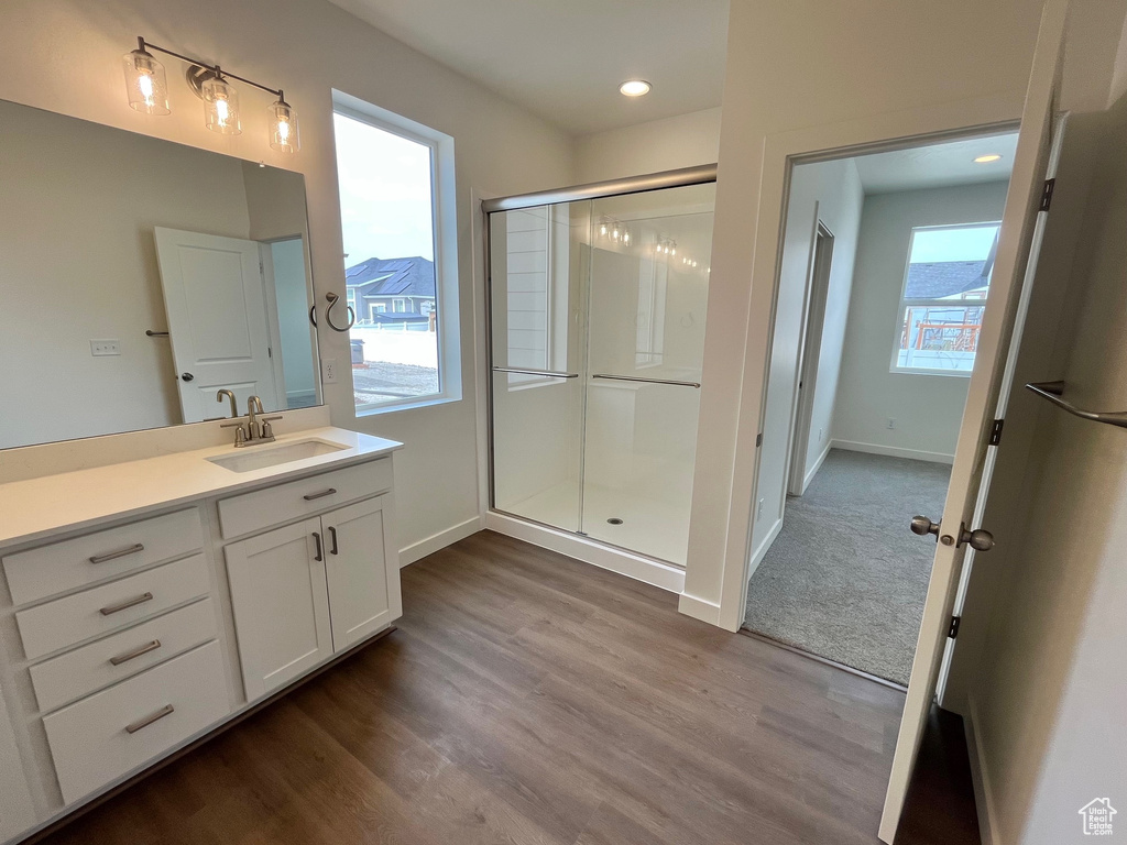 Full bath with wood finished floors, a stall shower, vanity, and recessed lighting
