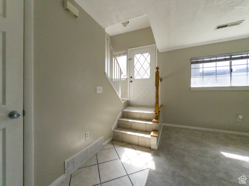 Stairs with tile patterned floors and baseboards