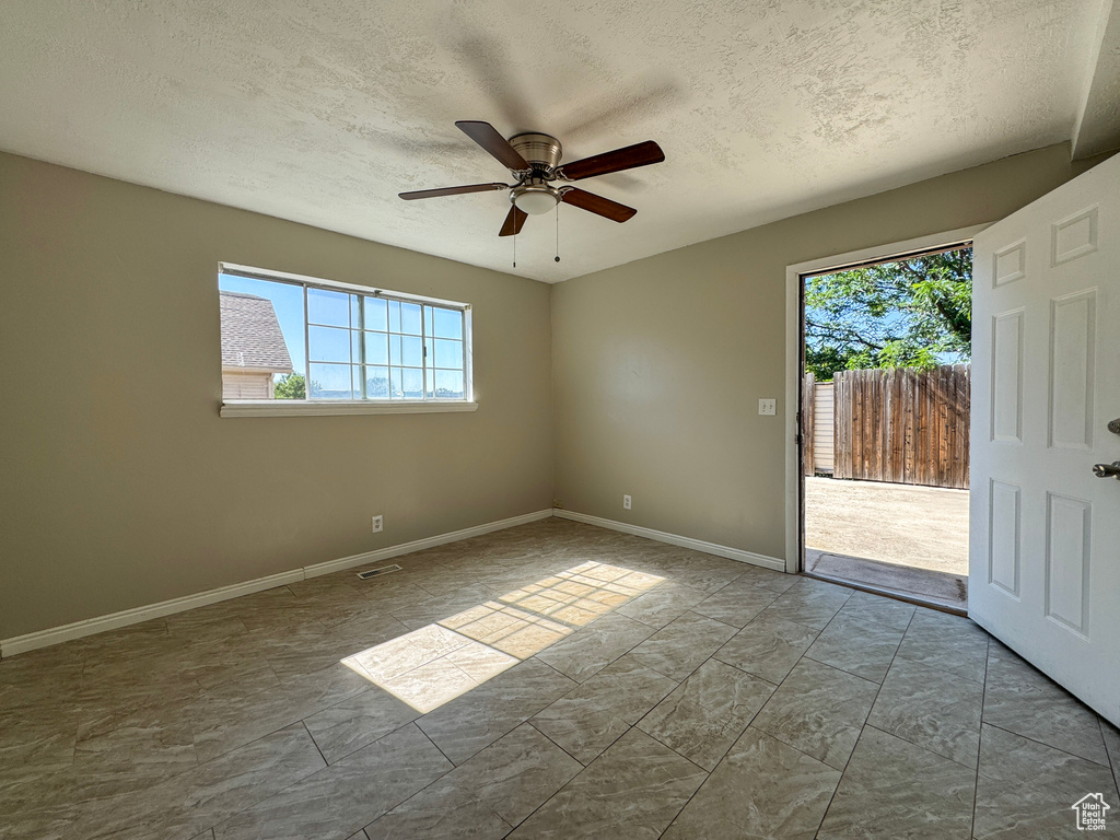 Unfurnished room featuring a textured ceiling and ceiling fan