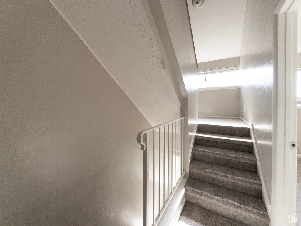 Stairway with attic access and vaulted ceiling