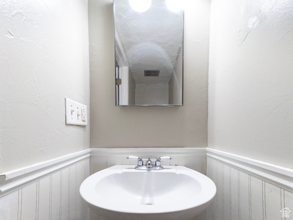 Bathroom with a wainscoted wall and a decorative wall