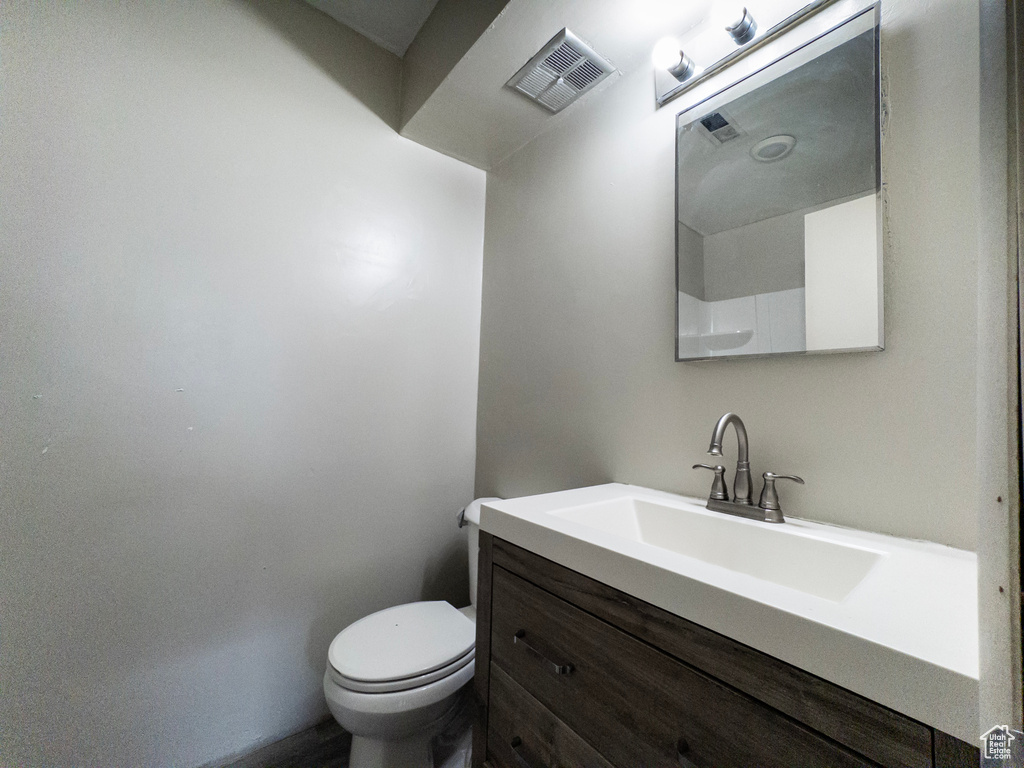 Half bathroom with vanity and toilet