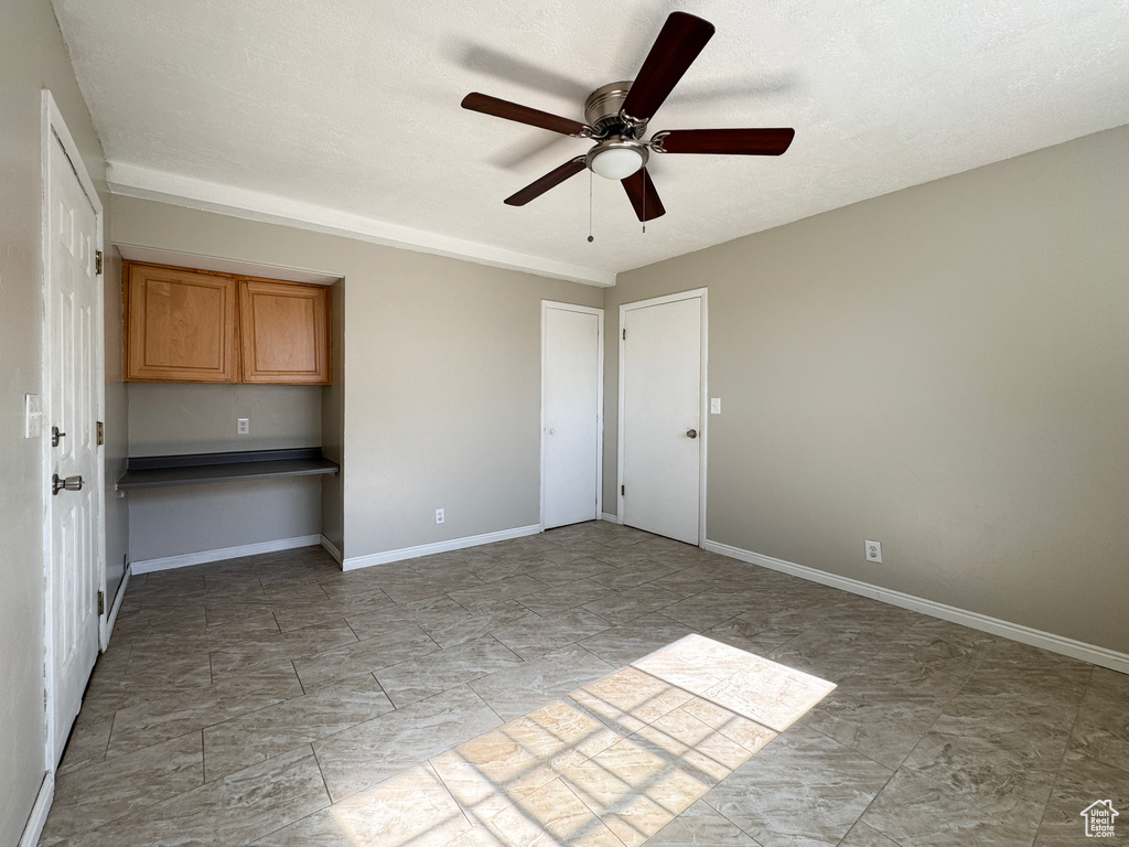 Spare room with ceiling fan and baseboards