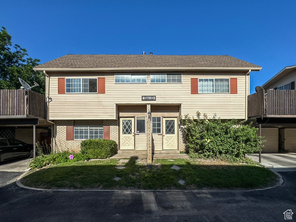View of front of home featuring brick siding and a shingled roof