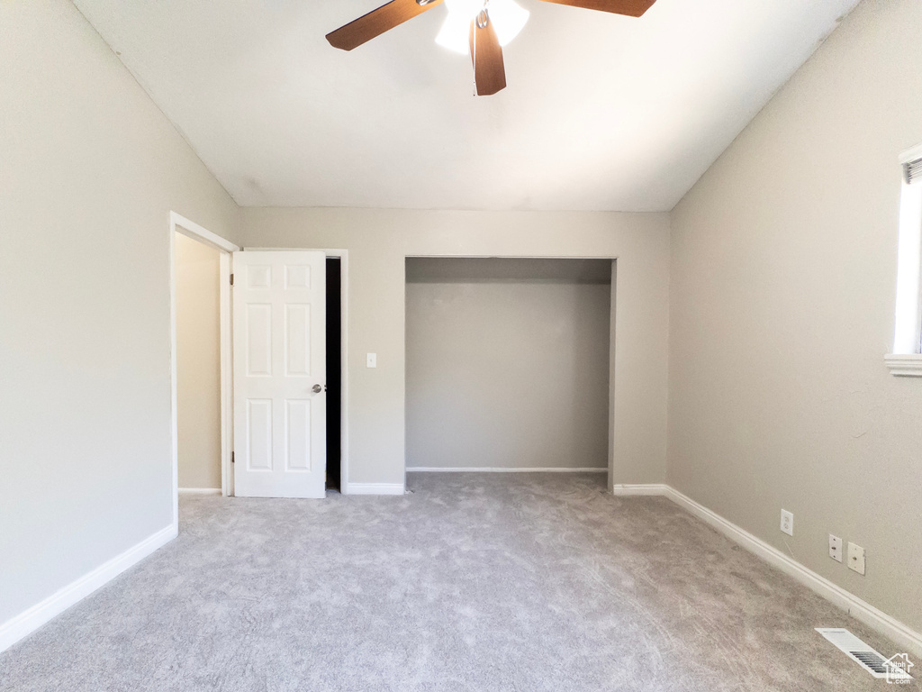 Unfurnished bedroom with carpet flooring, a closet, and ceiling fan