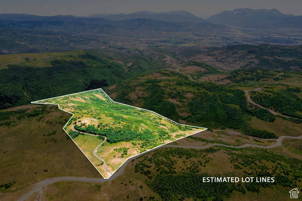 Aerial view of property and surrounding area featuring property parcel outlined and a mountain backdrop