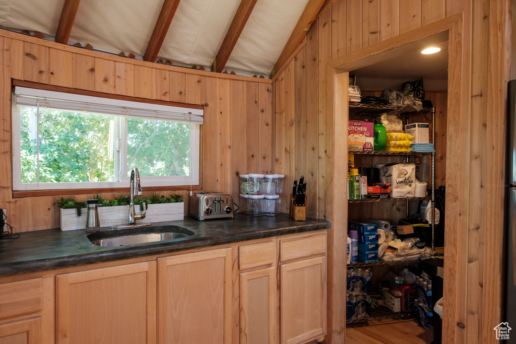 Kitchen featuring wood walls, beam ceiling, and wood finished floors