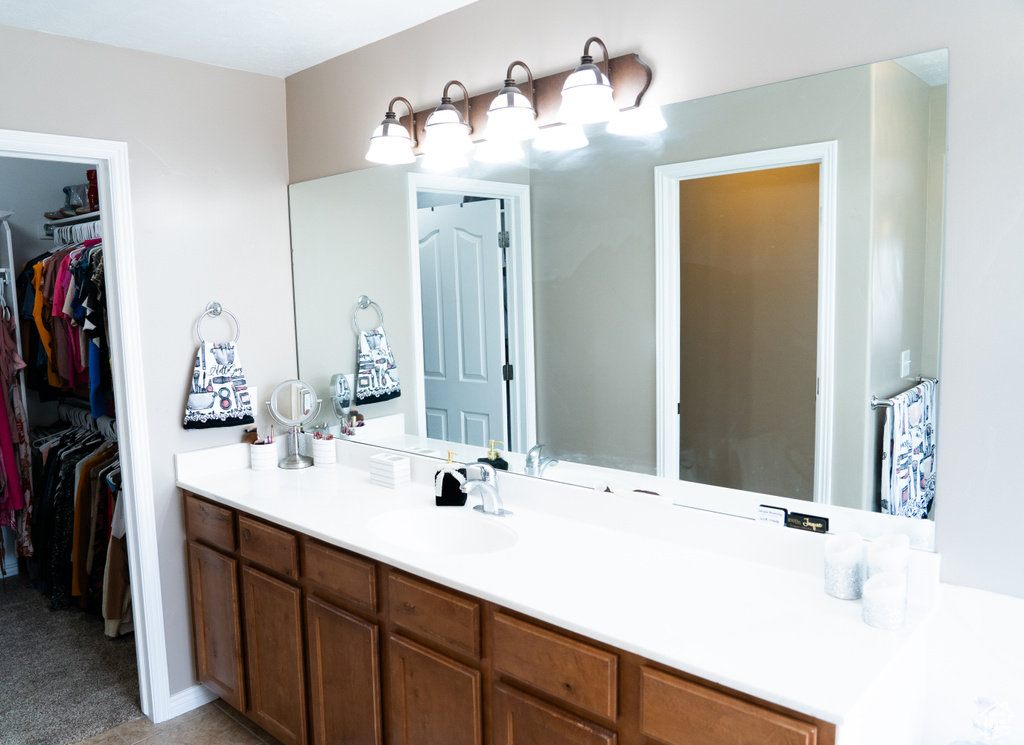 Bathroom with vanity and a spacious closet