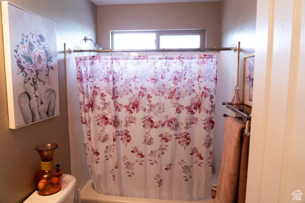 Full bath featuring shower / bath combo and toilet