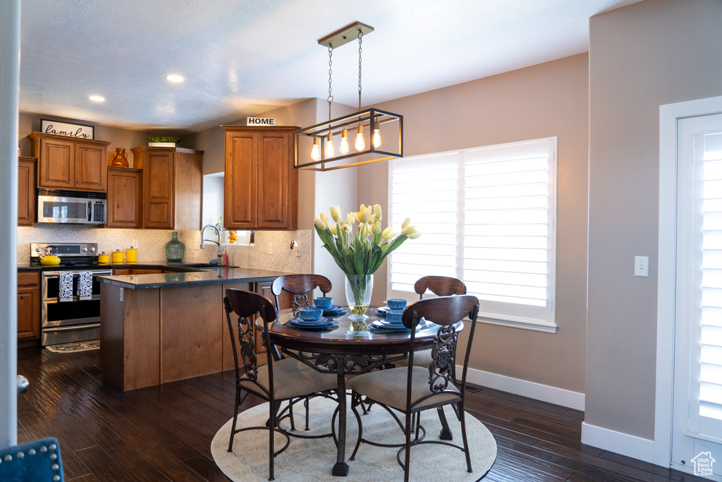 Dining room featuring healthy amount of natural light, dark wood-type flooring, and recessed lighting