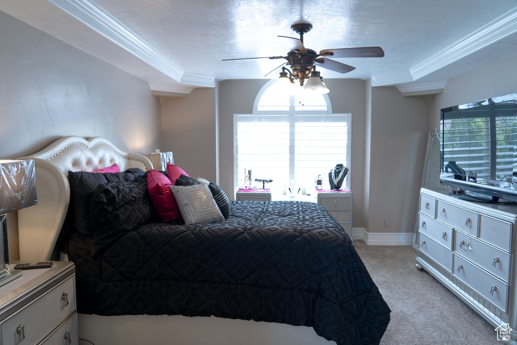 Bedroom with light carpet, crown molding, a ceiling fan, and a textured ceiling
