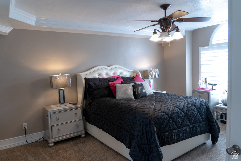 Bedroom with ornamental molding, carpet flooring, and a ceiling fan