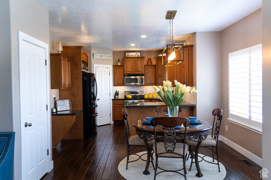 Dining room featuring dark wood finished floors and recessed lighting