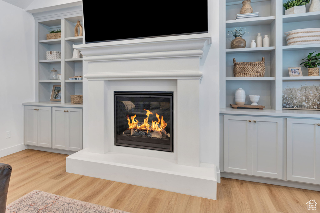 Detailed view of wood finished floors and a glass covered fireplace