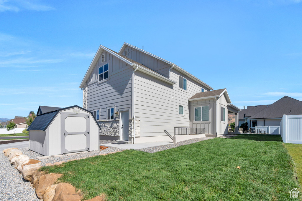 Rear view of house featuring a storage unit and board and batten siding