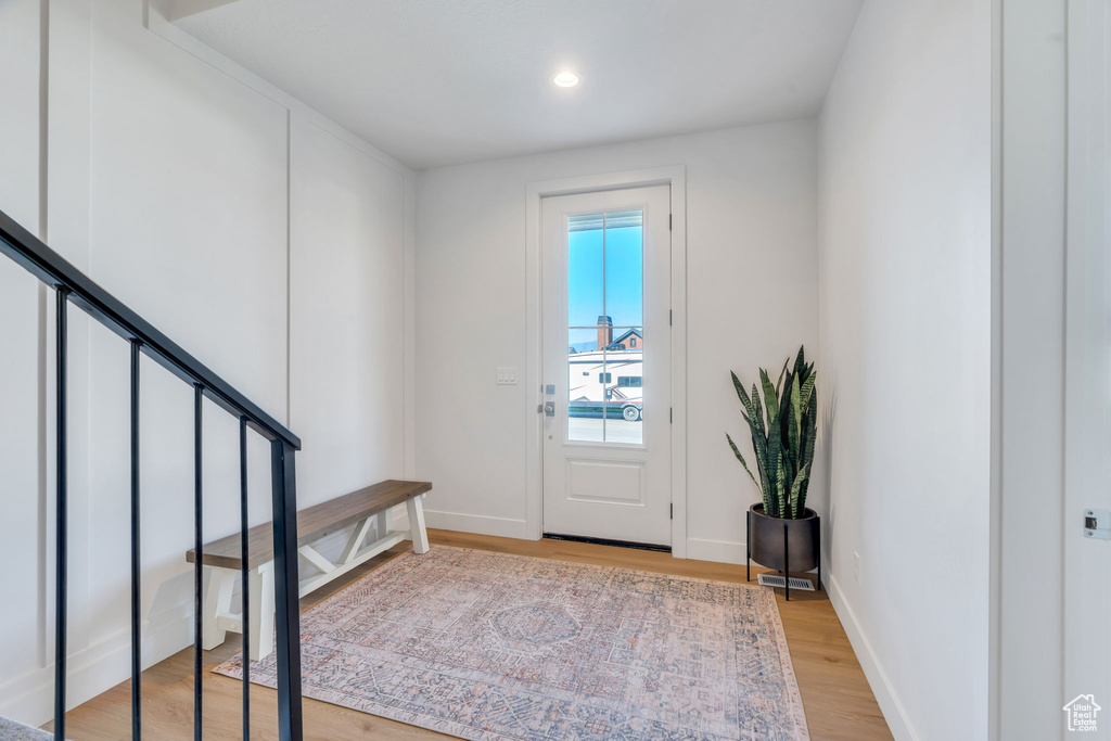Foyer entrance with light wood-style flooring, recessed lighting, and stairs