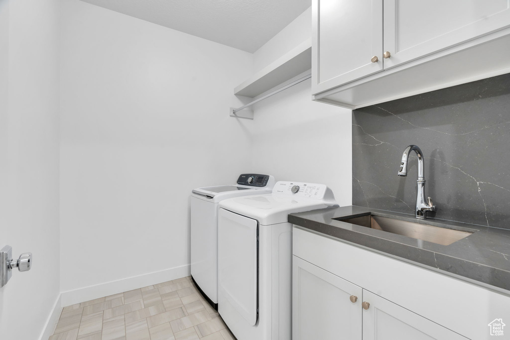 Washroom featuring cabinet space and washer and dryer