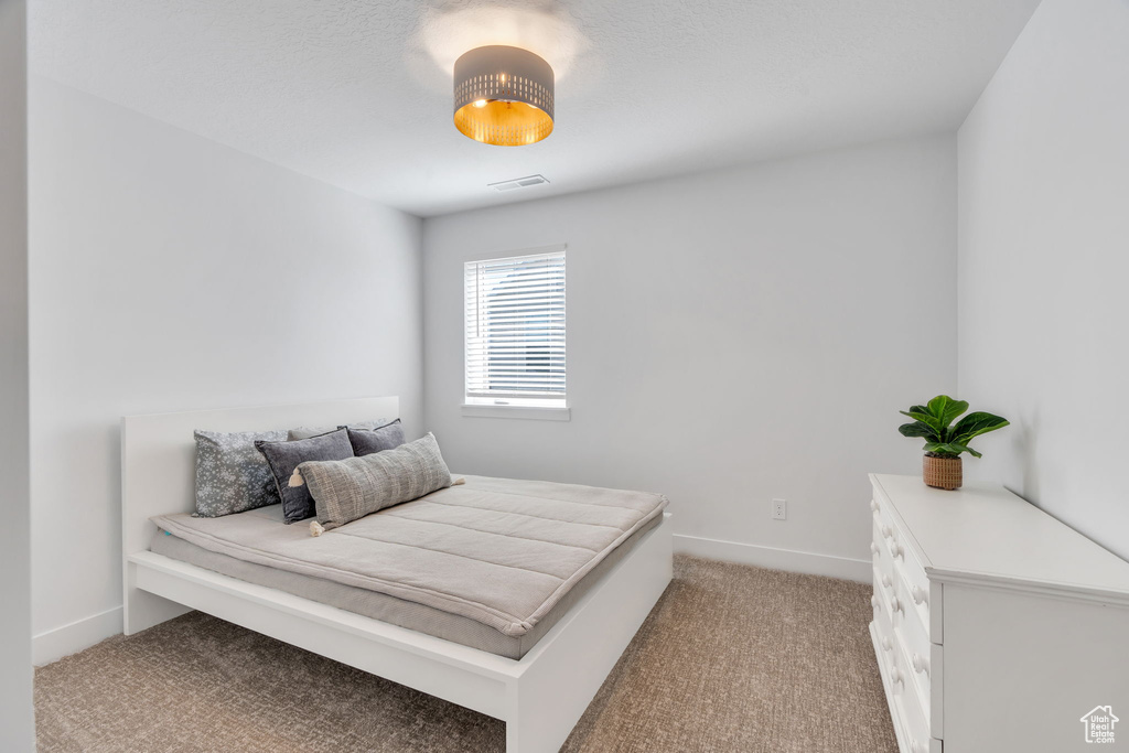 Bedroom featuring light carpet and baseboards