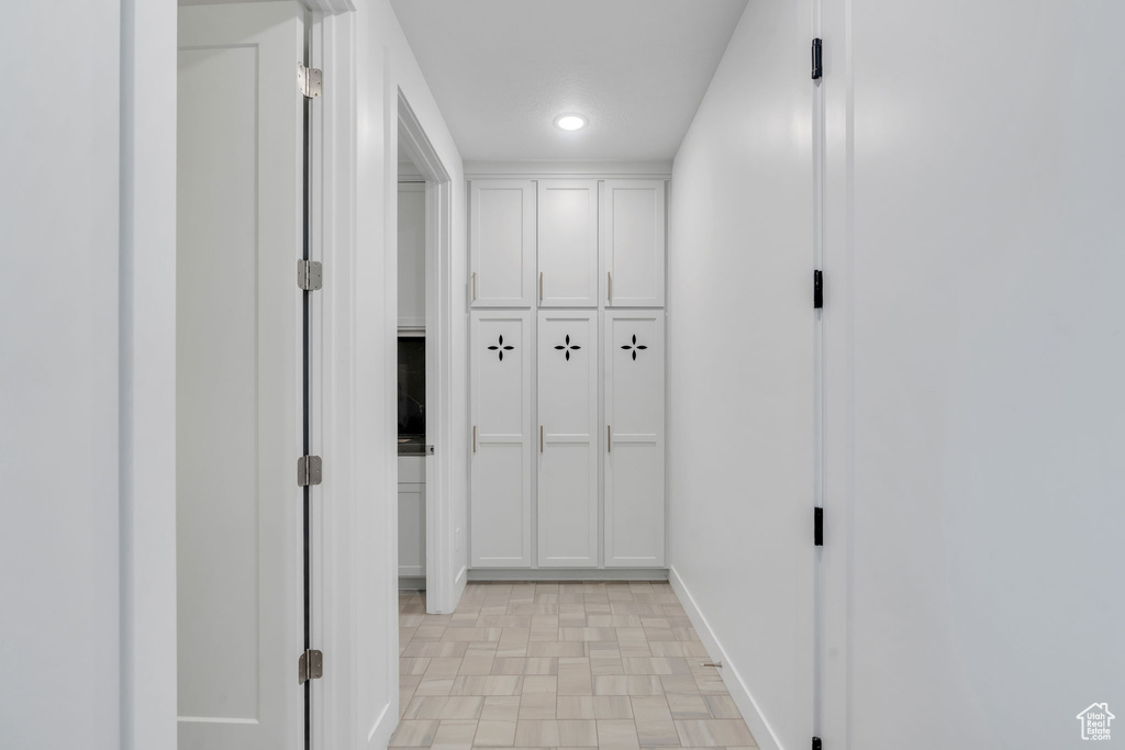 Corridor with recessed lighting and light flooring
