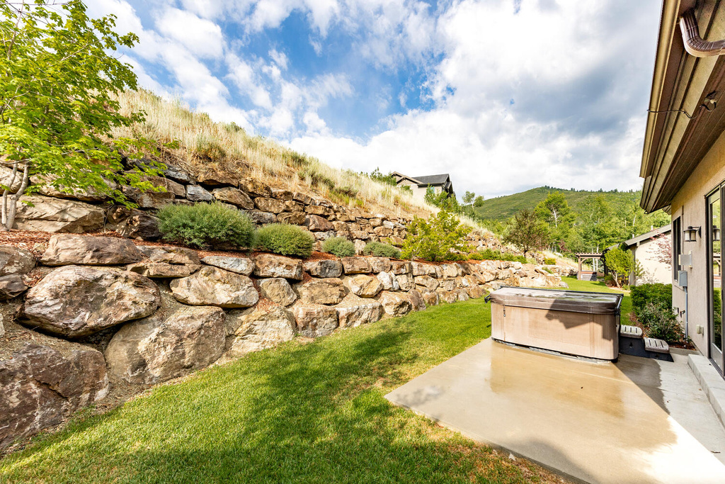 View of green lawn with a patio area and a mountain view