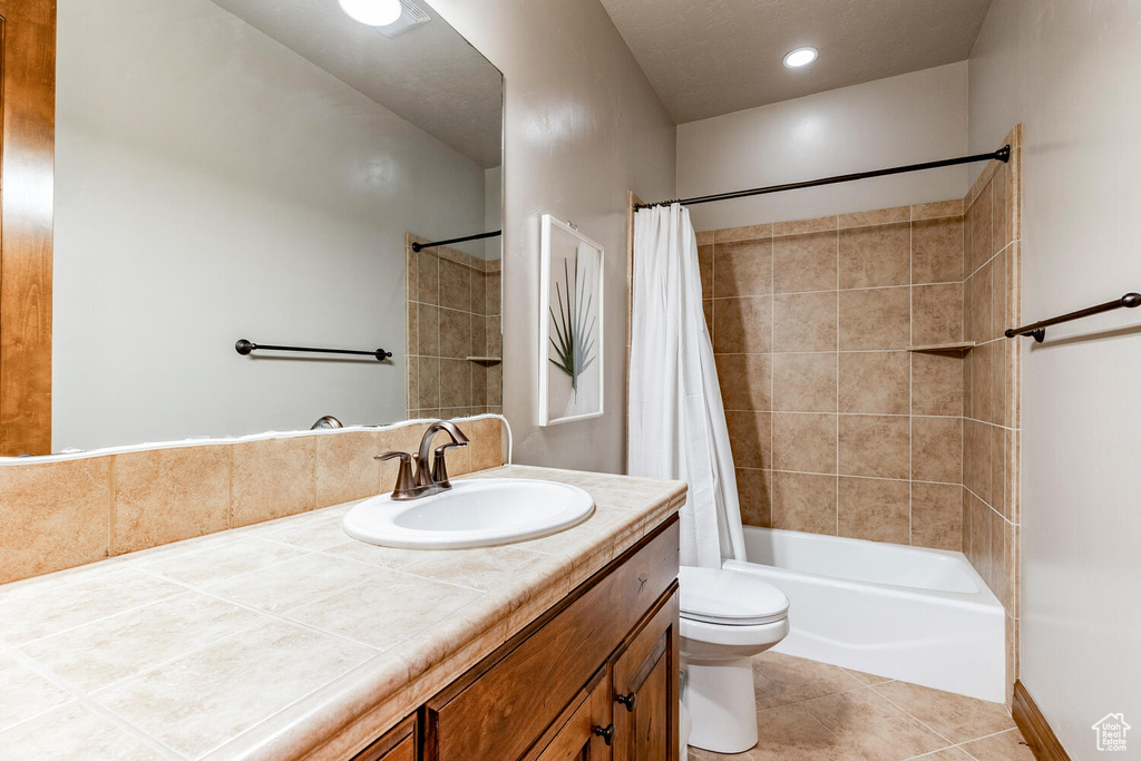 Bathroom with vanity, tile patterned flooring, and shower / bathtub combination with curtain