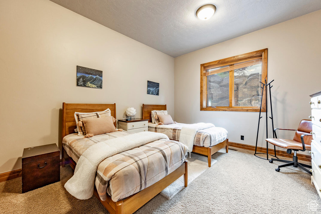 Bedroom featuring light colored carpet and baseboards