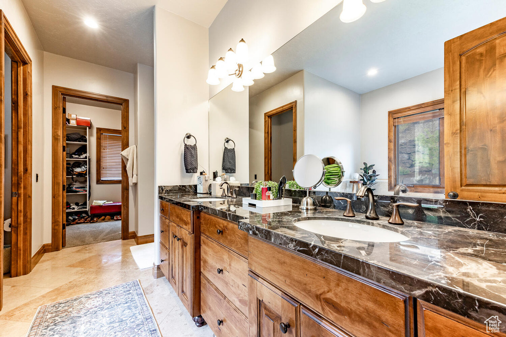 Bathroom with double vanity and a spacious closet