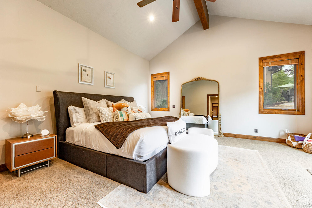 Bedroom with light carpet, beamed ceiling, high vaulted ceiling, arched walkways, and ceiling fan