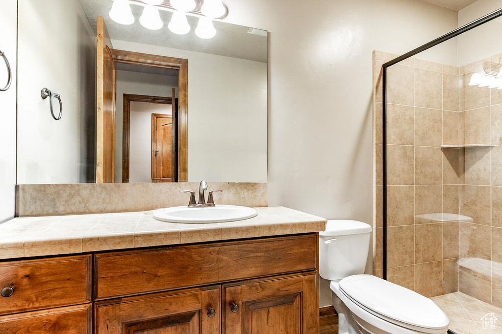 Full bath with vanity and tiled shower