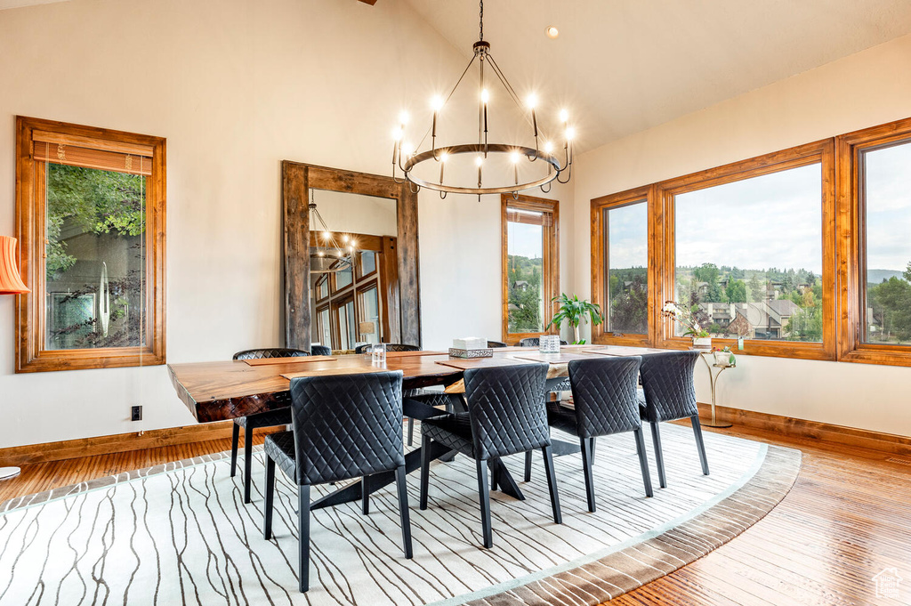 Dining room featuring a chandelier, hardwood / wood-style flooring, and high vaulted ceiling