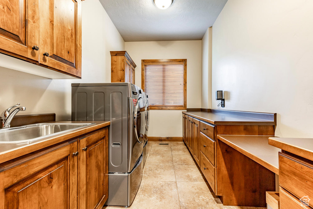 Laundry room featuring cabinet space and light tile patterned flooring