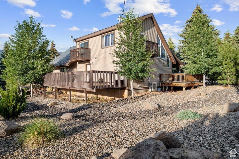Back of house with a balcony and a wooden deck