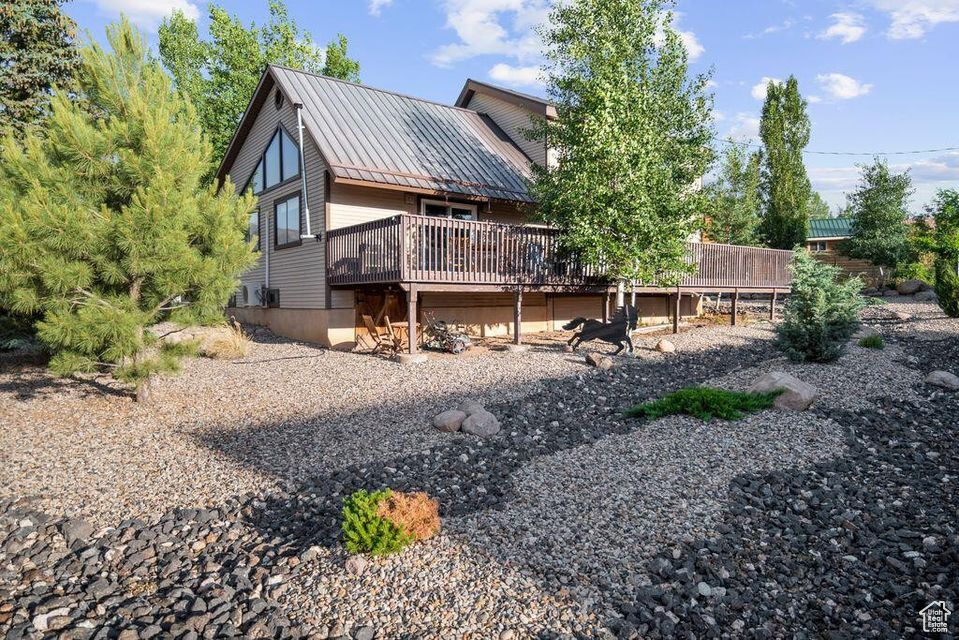Back of house featuring a deck and a metal roof