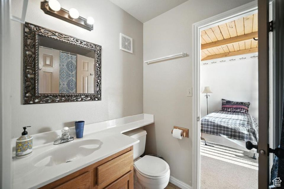 Bathroom featuring vanity and a wood ceiling with exposed beams