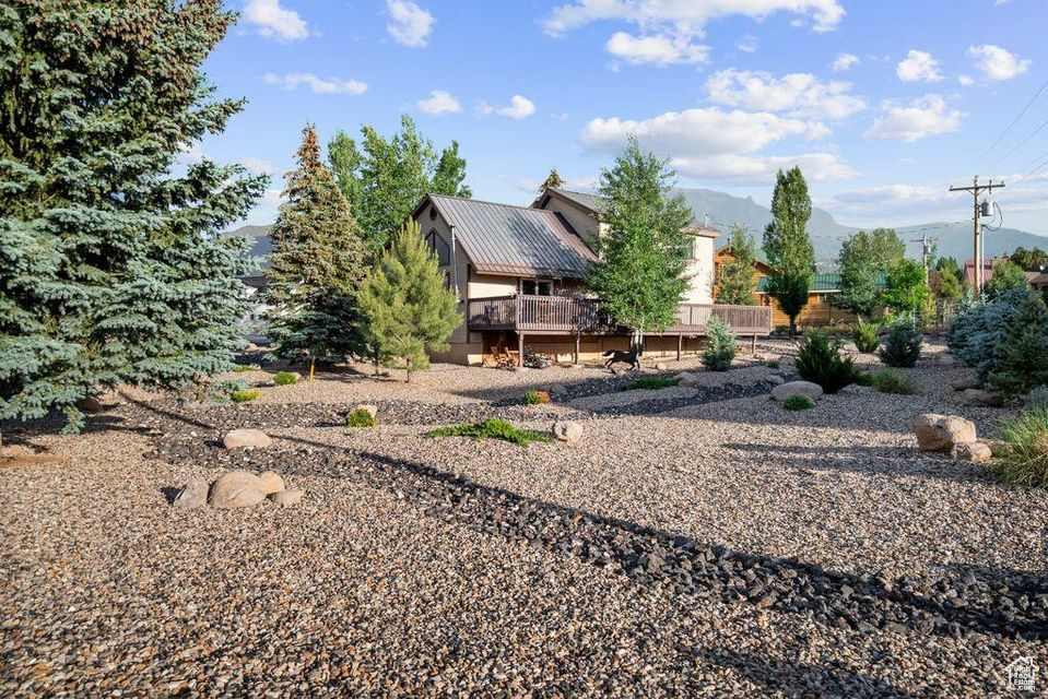 View of yard with a deck with mountain view