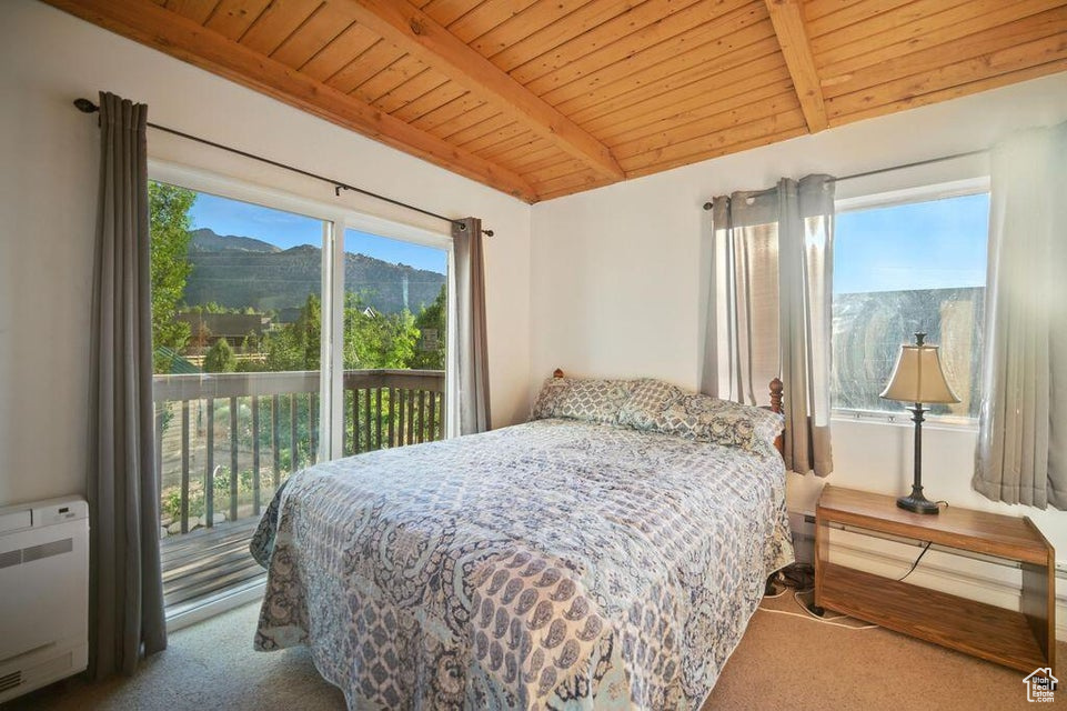 Bedroom featuring carpet floors, wood ceiling, access to outside, a mountain view, and radiator