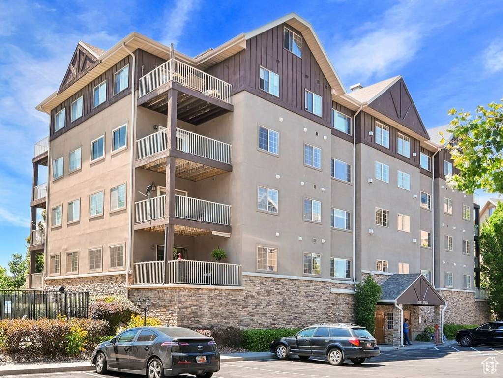 View of apartment building / complex with uncovered parking