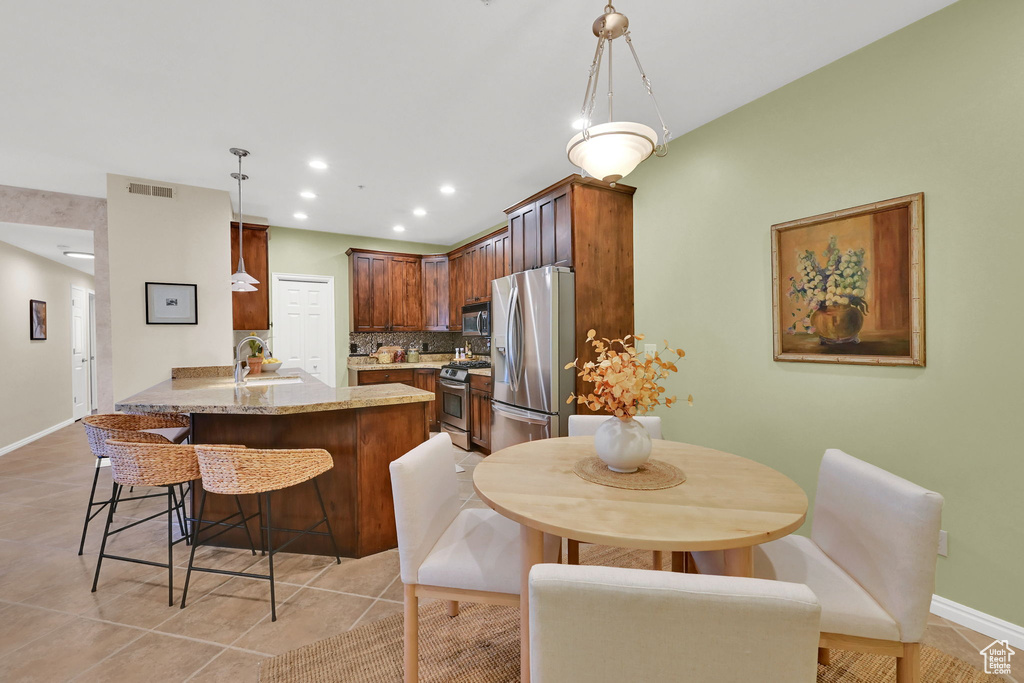Dining space featuring light tile patterned flooring and recessed lighting