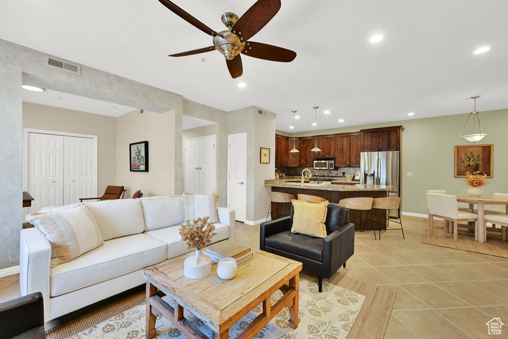 Living area featuring ceiling fan, recessed lighting, and light tile patterned floors