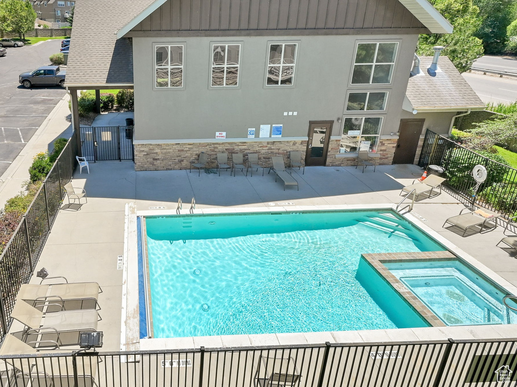 View of swimming pool with a patio and a pool with connected hot tub