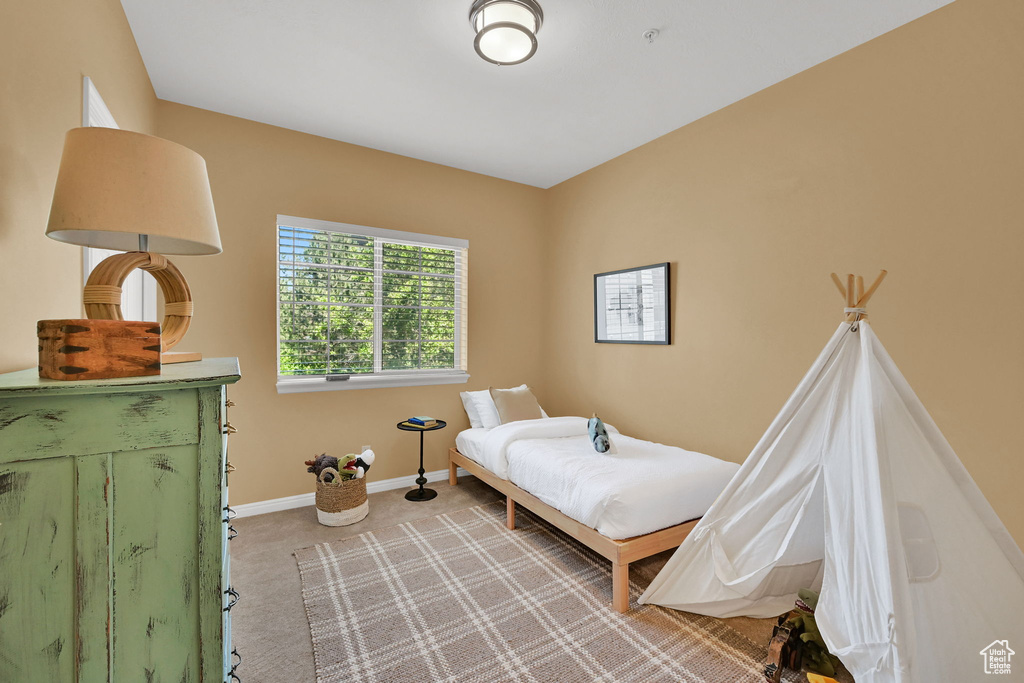 Bedroom featuring light carpet and baseboards