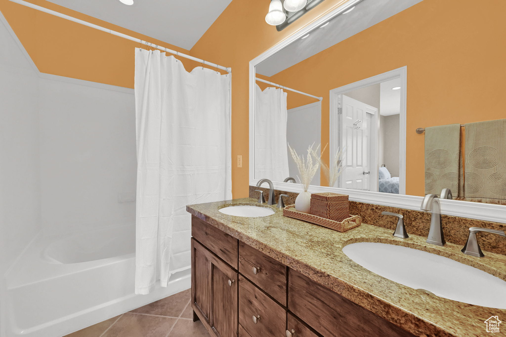 Full bath with double vanity, tile patterned flooring, shower / bathtub combination with curtain, and ensuite bathroom