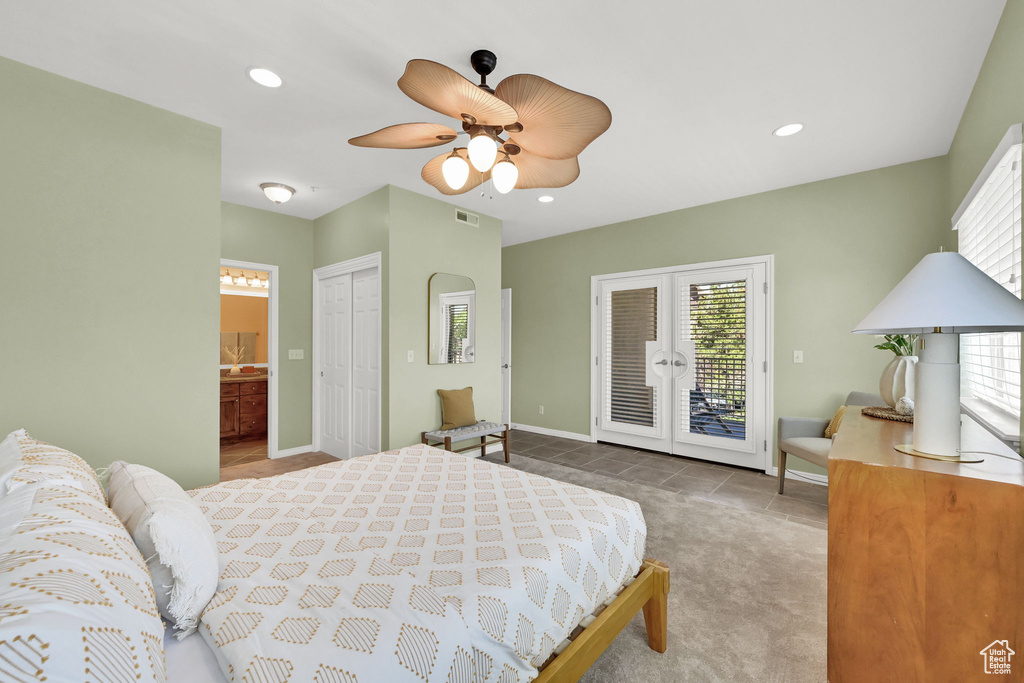 Tiled bedroom featuring access to exterior, multiple windows, ensuite bath, recessed lighting, and a ceiling fan