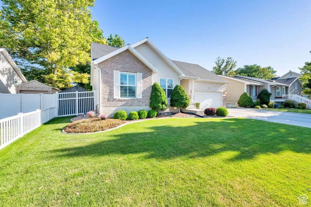 Ranch-style home featuring a garage, driveway, and brick siding
