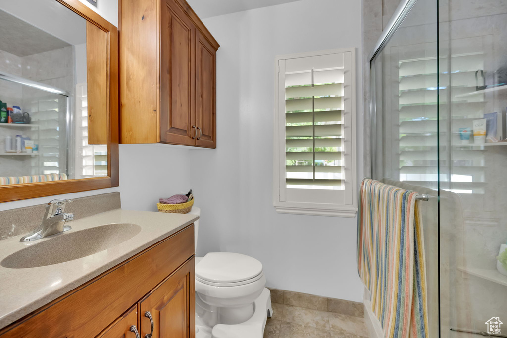 Full bath featuring vanity, a stall shower, and tile patterned floors