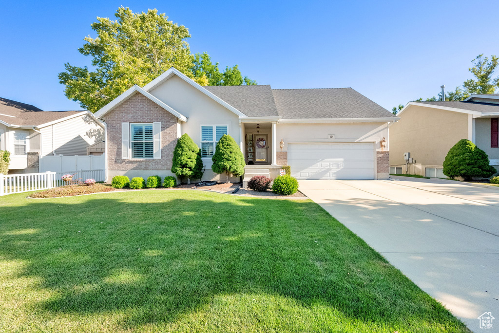 Single story home with brick siding, a garage, driveway, stucco siding, and roof with shingles