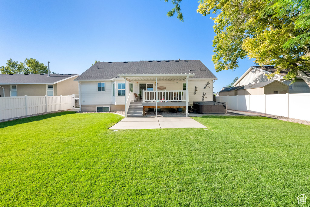 Back of house featuring a hot tub, a patio, a fenced backyard, a pergola, and a wooden deck