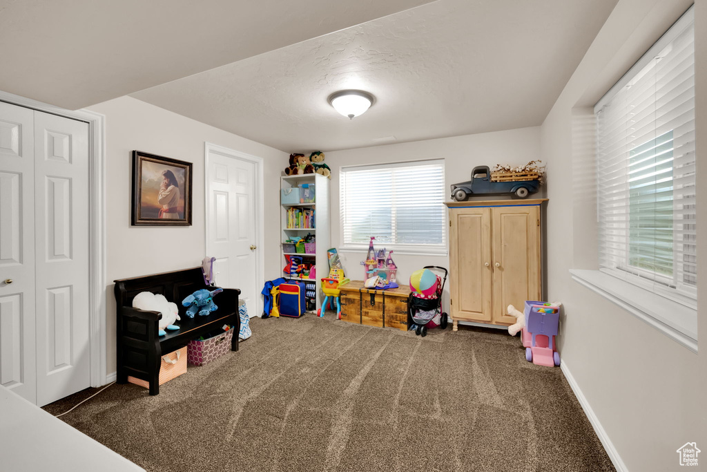Playroom with dark colored carpet and baseboards